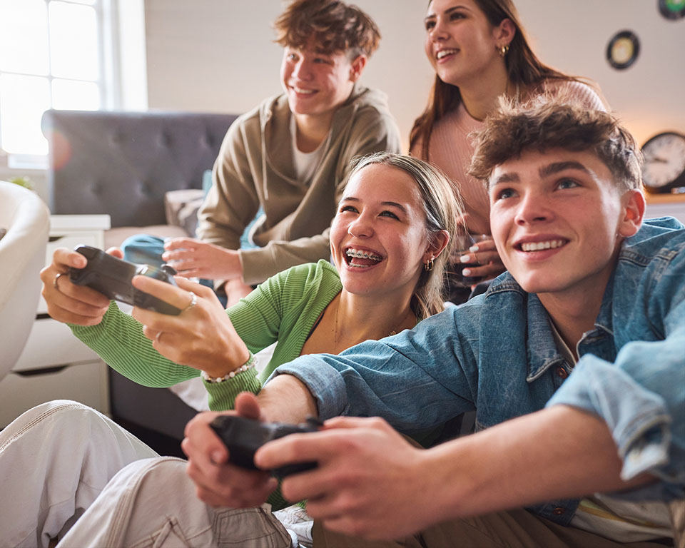 teens playing video games, one with braces on