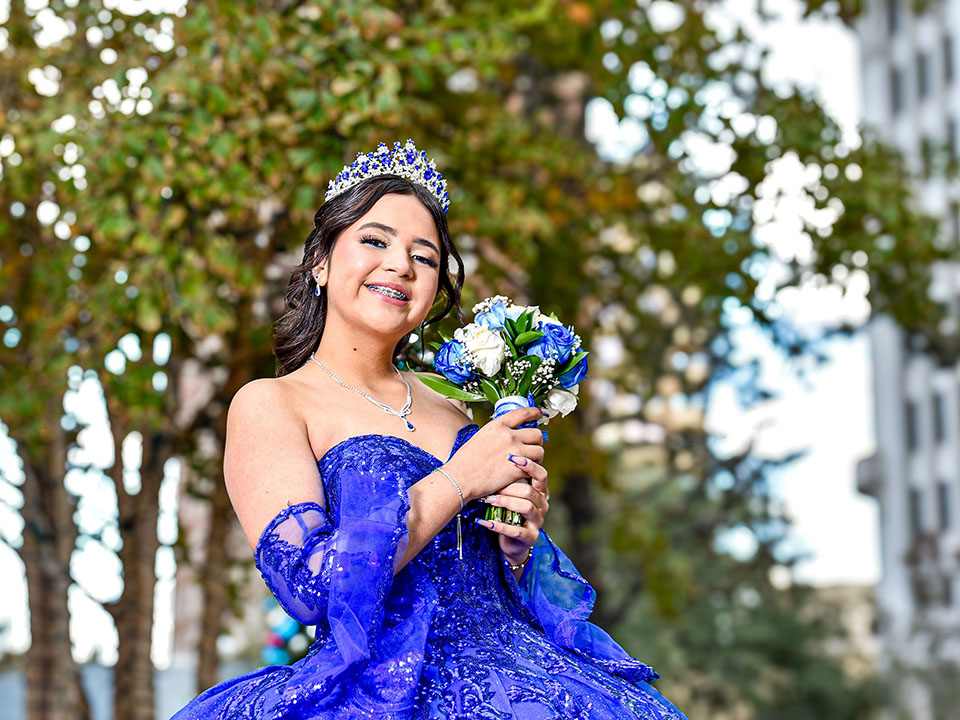 girl at her quinceanera with braces and a blue dress